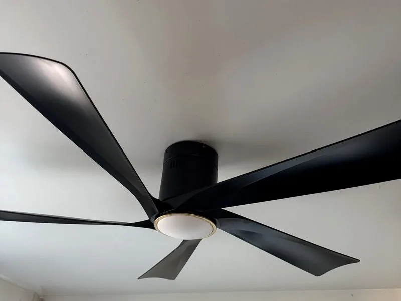 New low-profile black five-blade ceiling fan with integrated LED light mounted flush to the ceiling