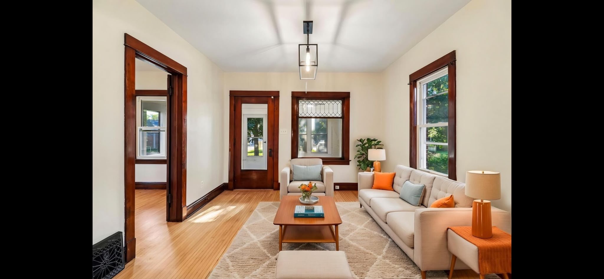 Living room after painting with light walls, a white ceiling and original dark wood trim