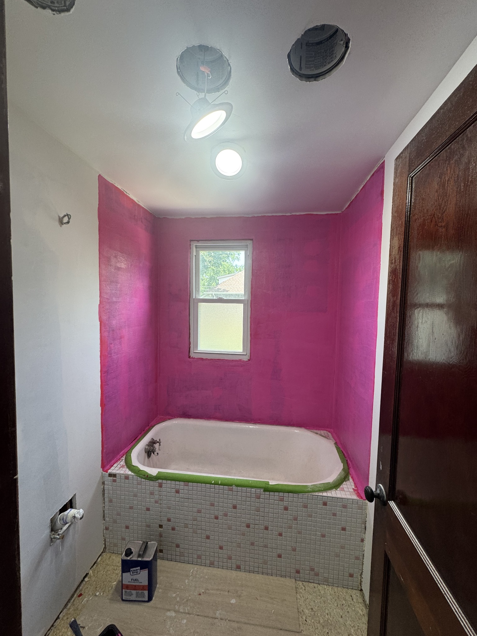 Wallpaper and vanity removed, with wall preparation underway before tiling. Bathroom remodeling project in Joliet, Illinois.